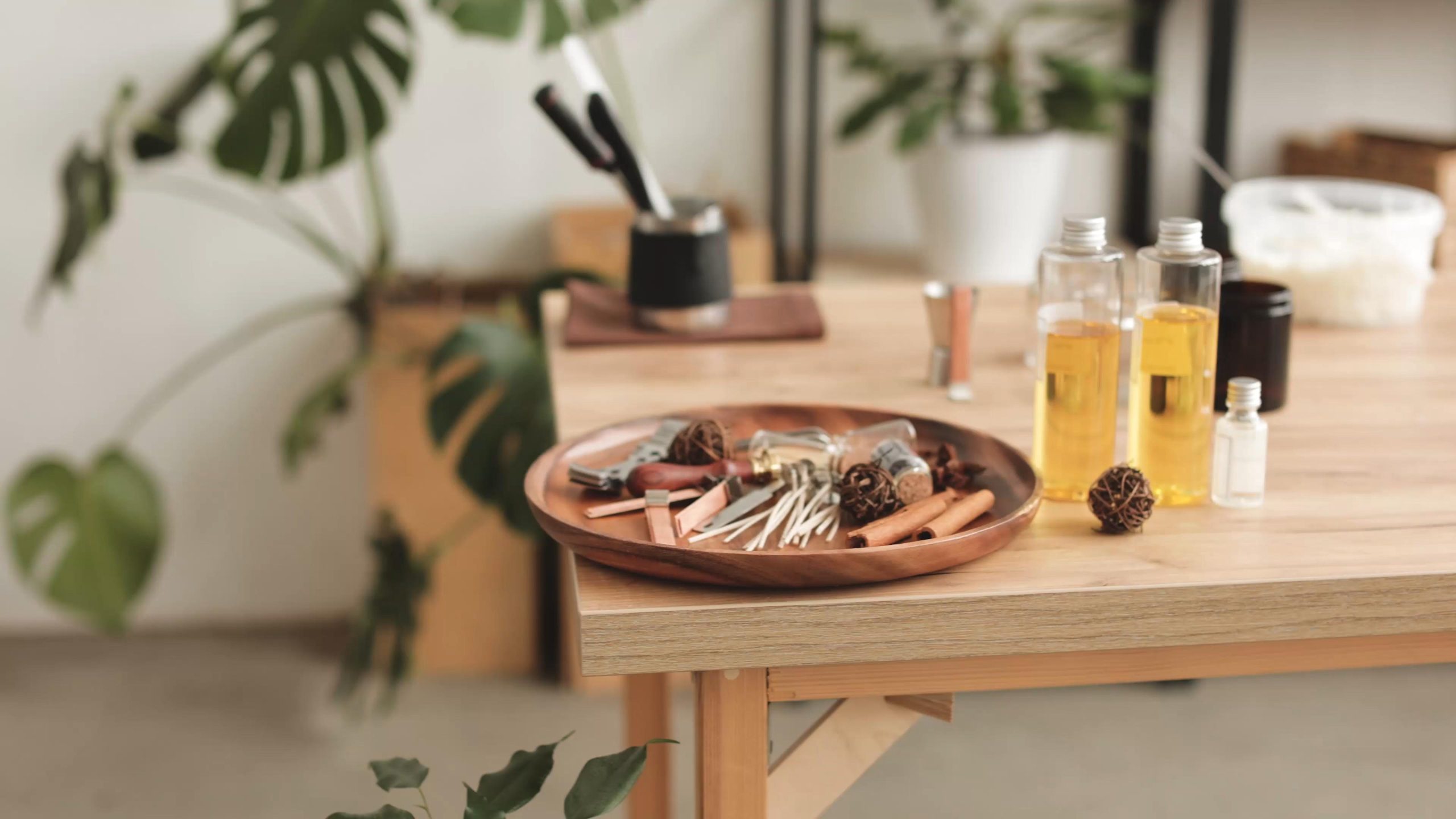 A still life of matches, fragrance oils, and ritual objects on a table.