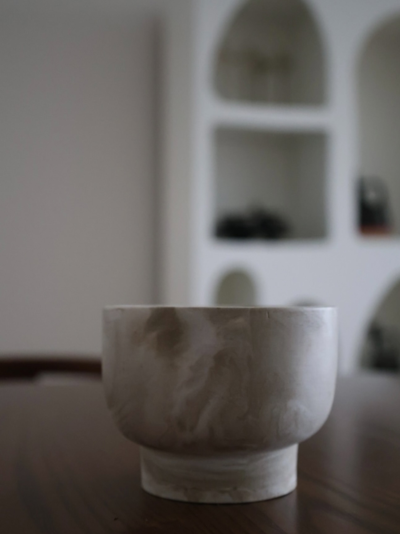 A close view of a handmade vessel candle with a wood wick.